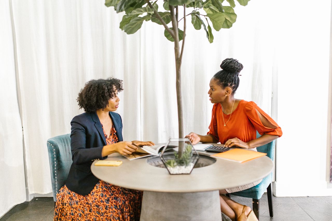 Two women reviewing insurance documents together during a one-on-one financial consultation